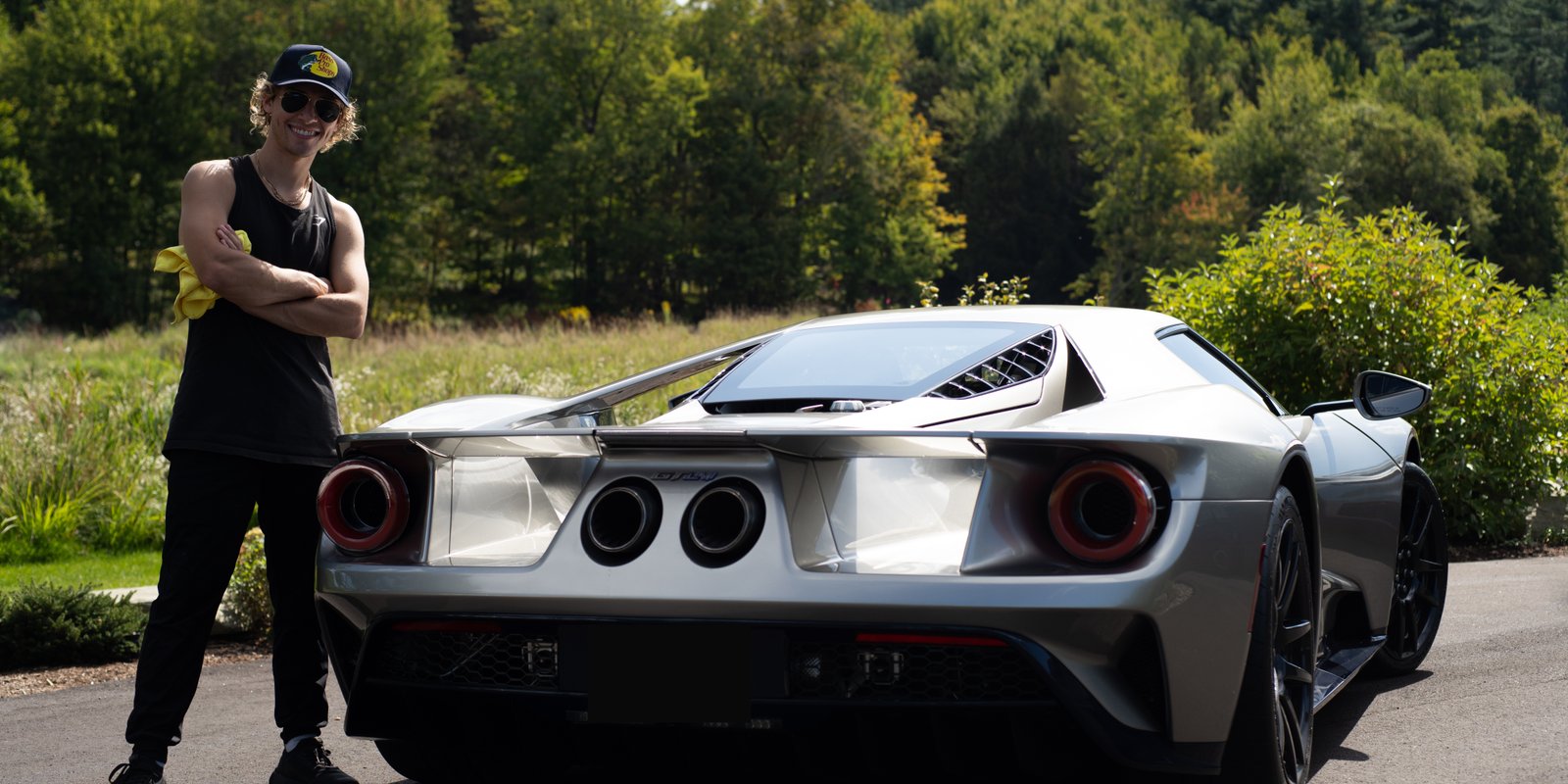 Jake Ramos CEO and Head Detailer standing next to a happy customers Ford GT LM