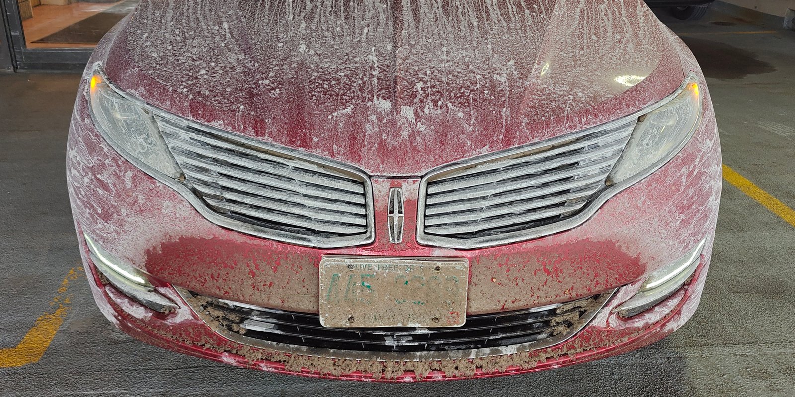 Picture of car parked in a garage, covered in salt and snow from a long drive down from the North