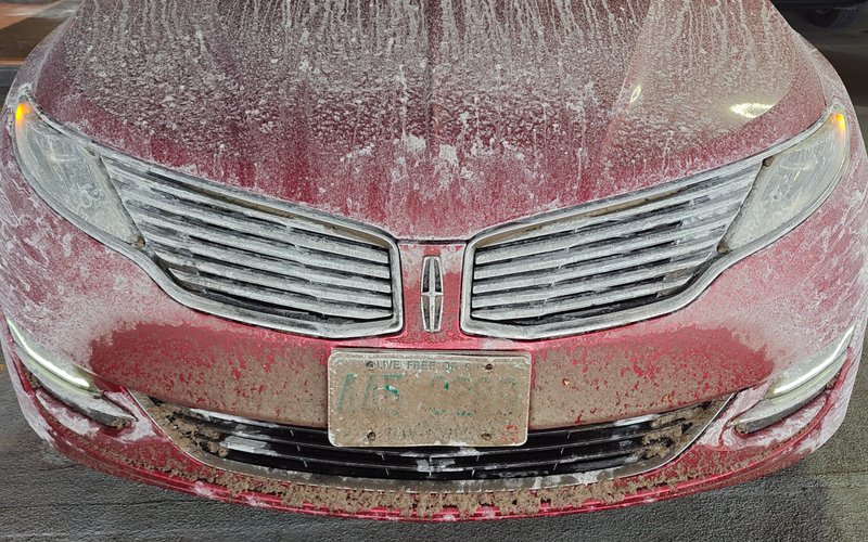 Picture of car parked in a garage, covered in salt and snow from a long drive down from the North