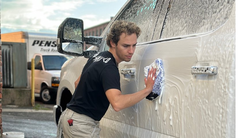 Technician spraying foam on a large grey van